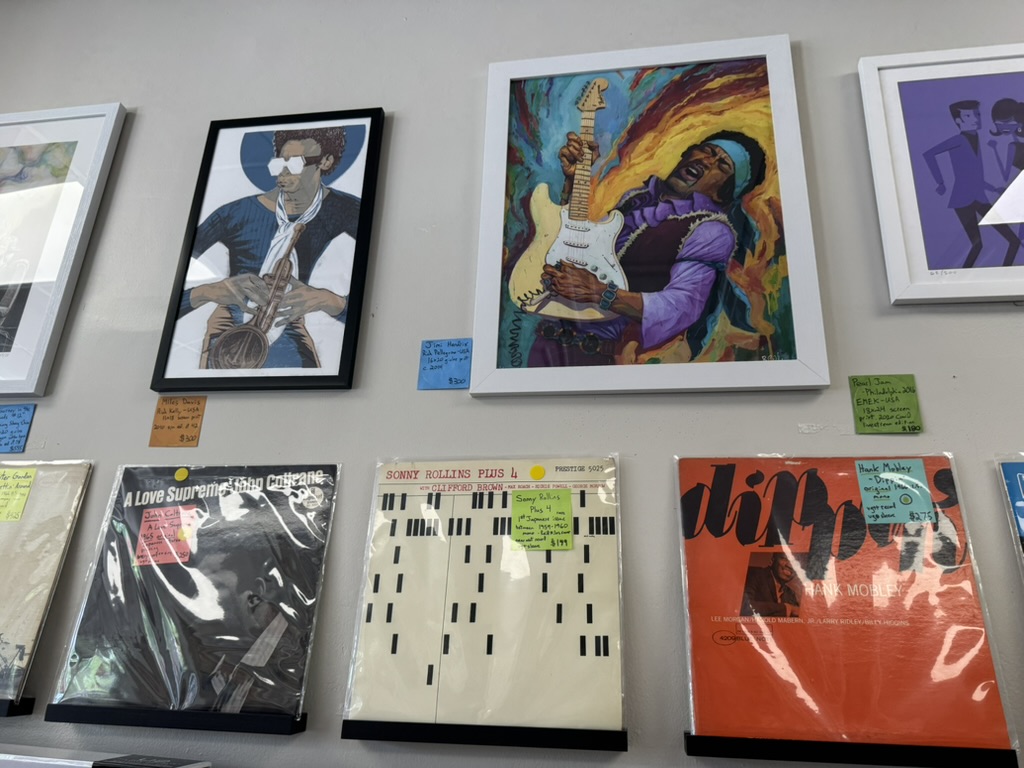 Framed music art above jazz records including Coltrane, Sonny Rollins, and Hank Mobley