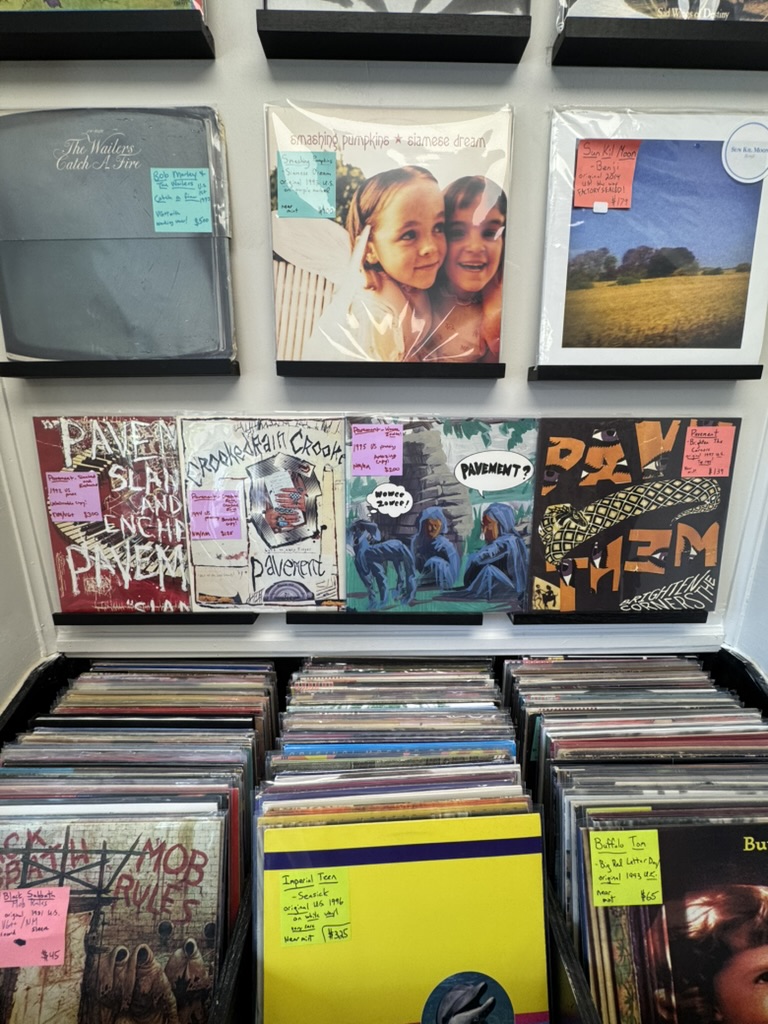 Pavement and other titles on the wall above a packed record bin