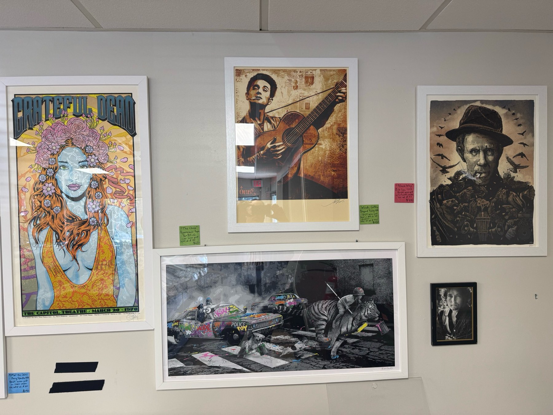 Framed prints on the wall, including Grateful Dead, Woody Guthrie, and Tom Waits